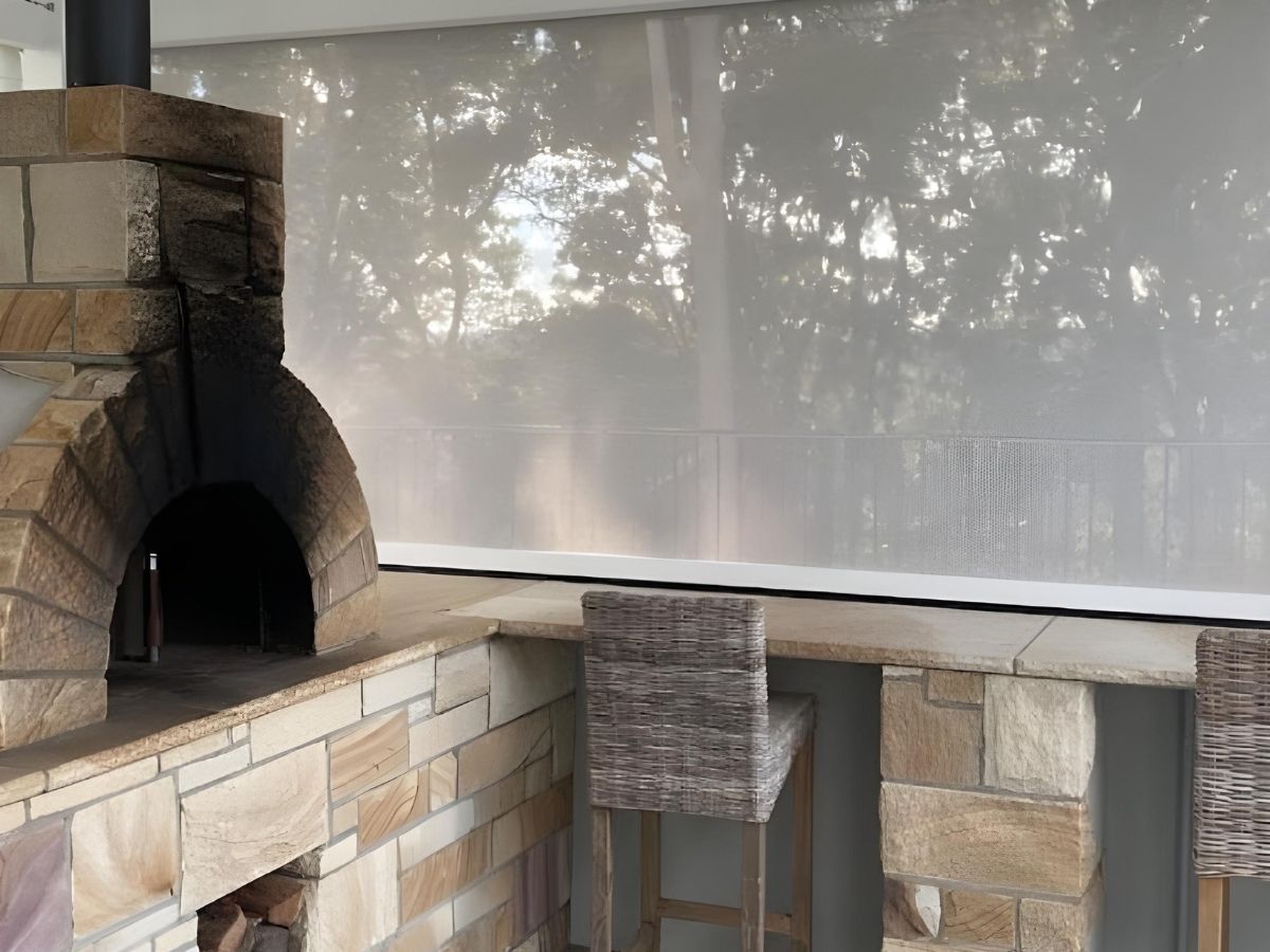 Ozrite HD Channel outdoor blind in Shale Grey 95 on an alfresco barbecue area for shade, privacy and weather protection