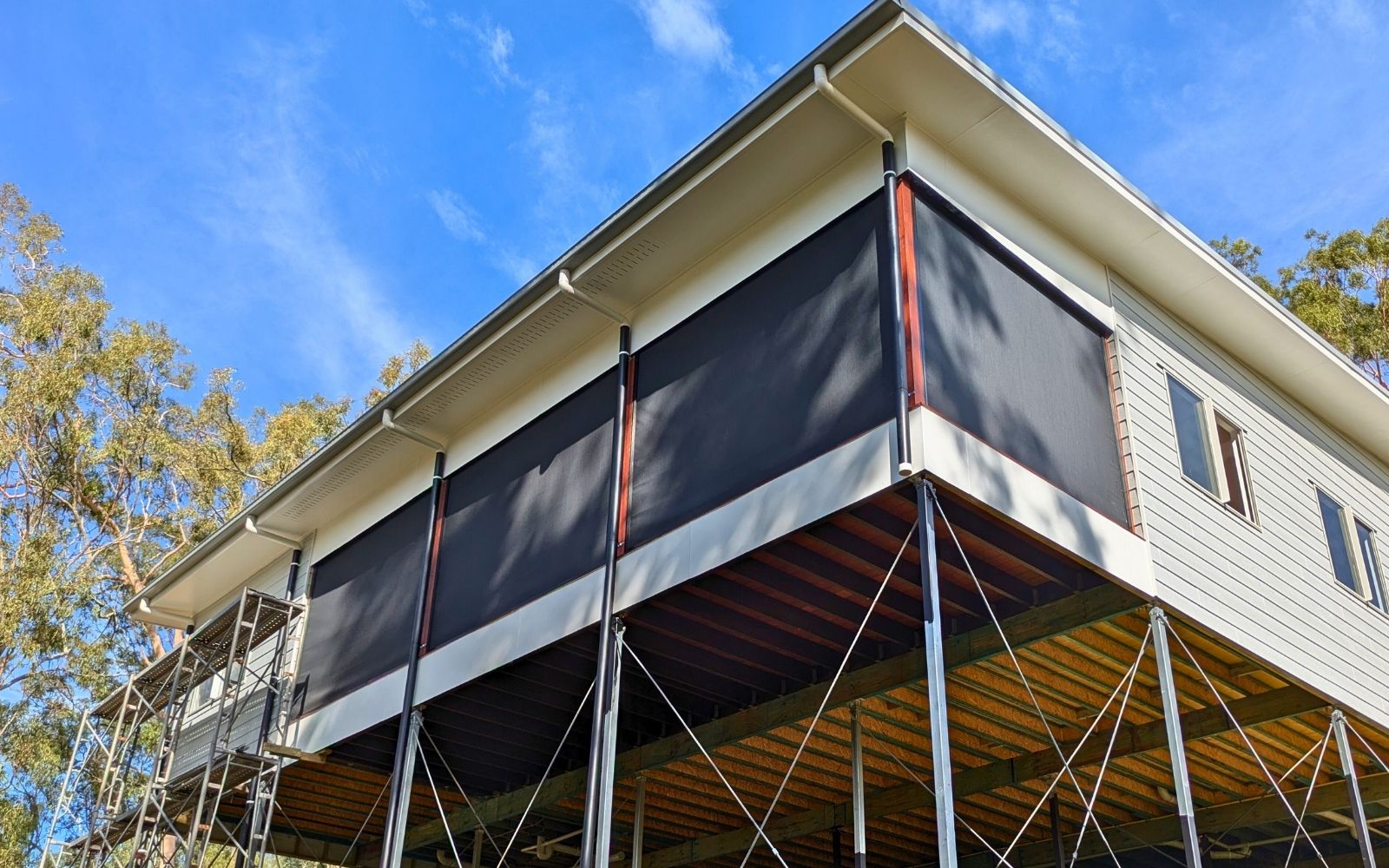 Wind Rated Outdoor Blinds installed on a modern Australian patio, blocking wind while allowing a clear view