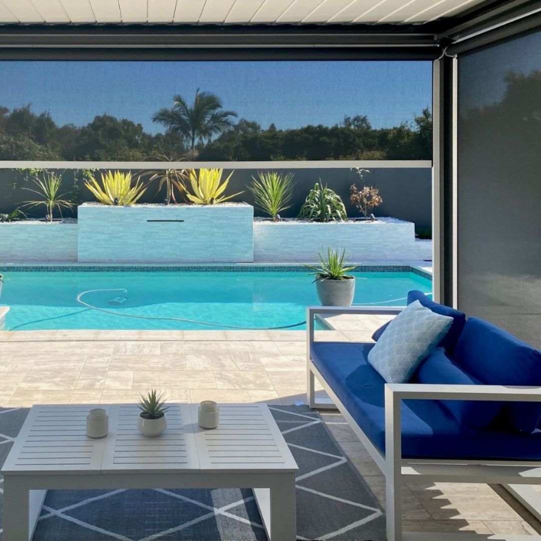 Custom Ozrite outdoor blinds on a poolside patio, providing shade, privacy, and insect protection.