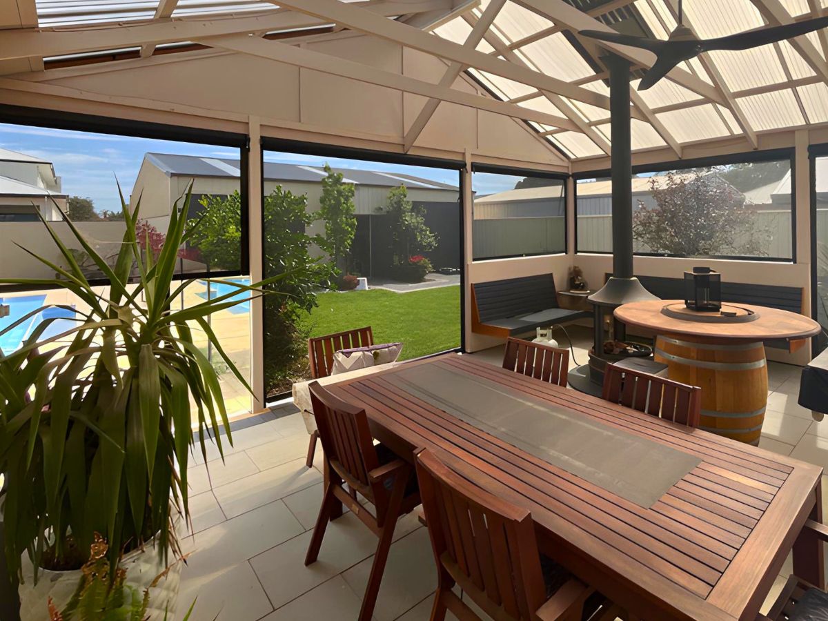 Insect-proof outdoor blinds enclosing an alfresco dining area with pool views — block mozzies and bugs without losing visibility.