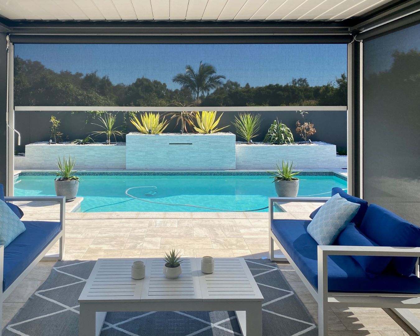 Ziplock track system engineering diagram next to a premium poolside patio installation, demonstrating how the welded zipper locks into the vertical aluminium side channel to eliminate edge gaps.